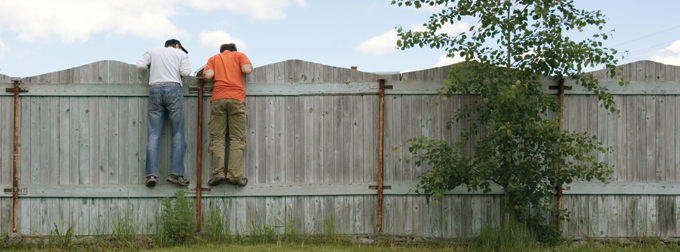 Kids peering over a fence